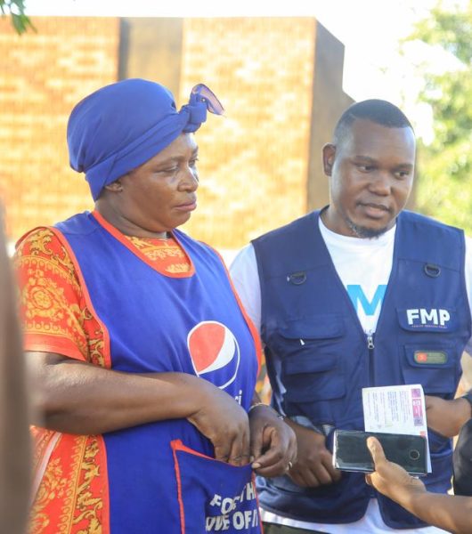Enock (center) giving SRHR information to the women in Nakiwogo